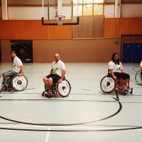 Fünf Rollstuhlbasketballer auf dem Spielfeld