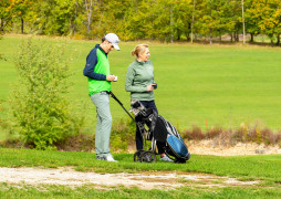 Spieler mit Caddy und Golfausrüstung