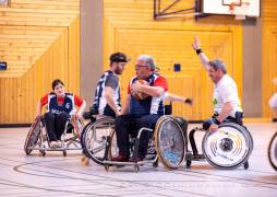 Bürgermeister Metzner im Rollstuhl verteidigt den Basketball mit fröhlichem Grinsen